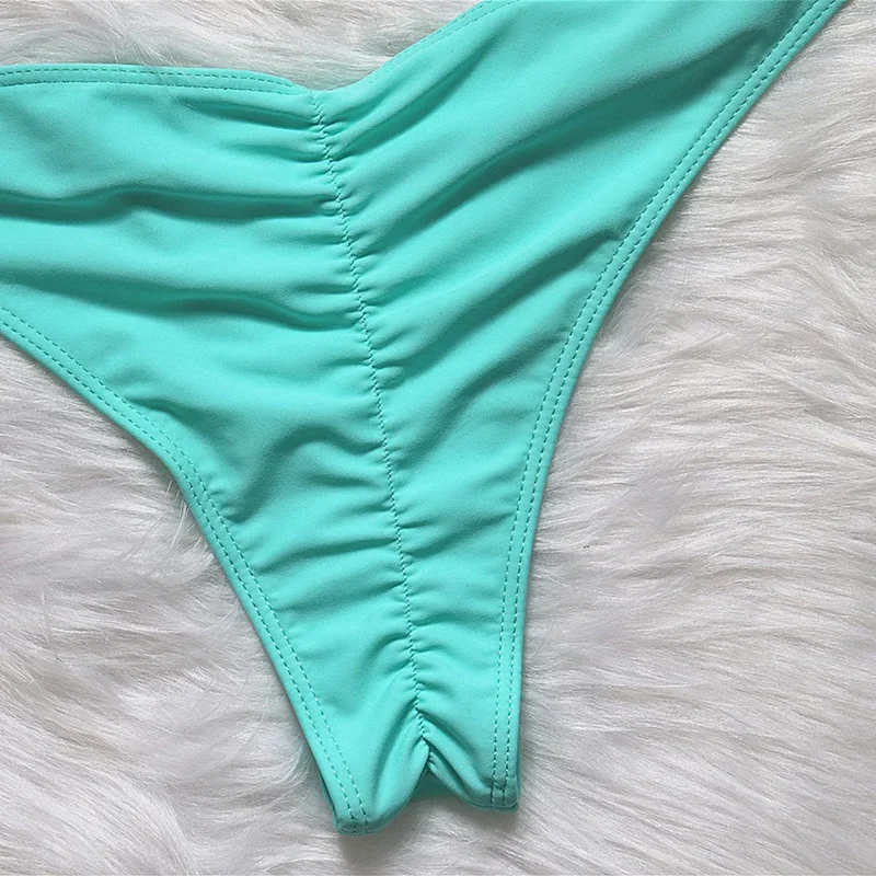 Turquoise bikini bottom on a light gray fur surface