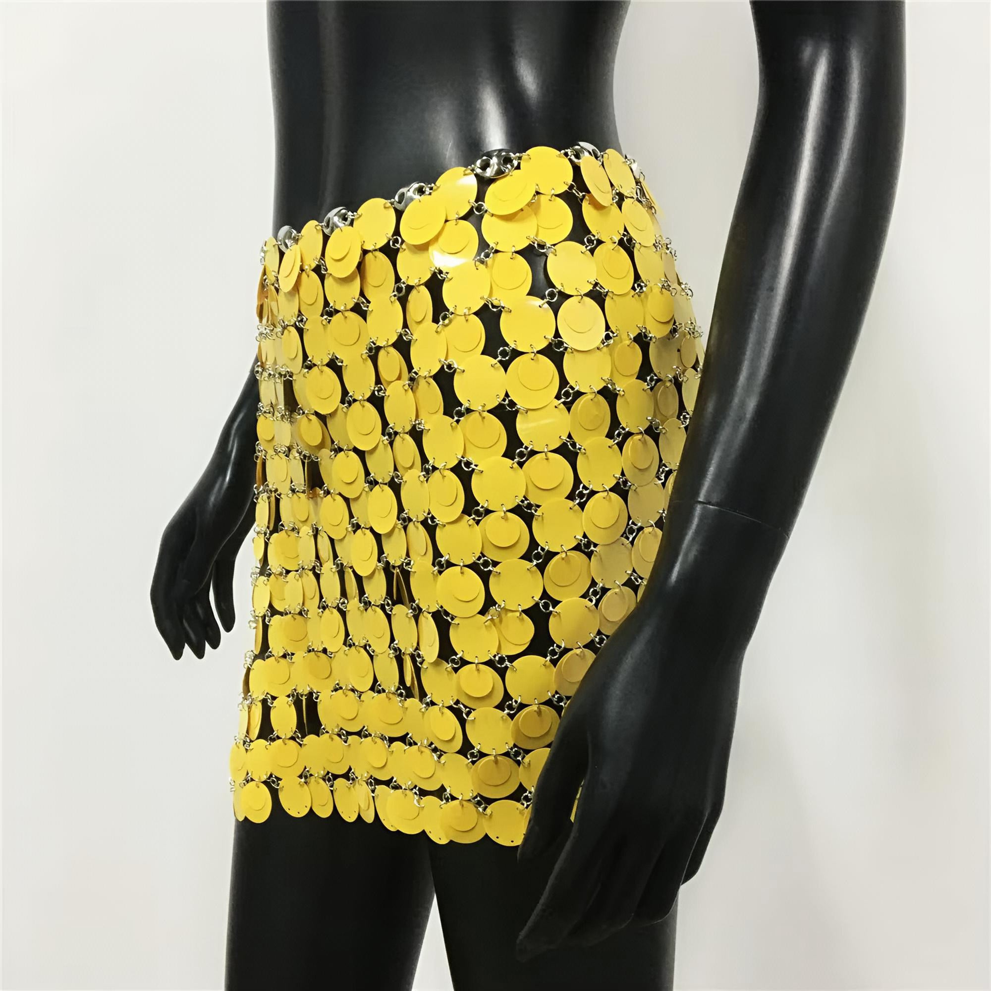 Yellow sequin skirt on a black mannequin against a white background
