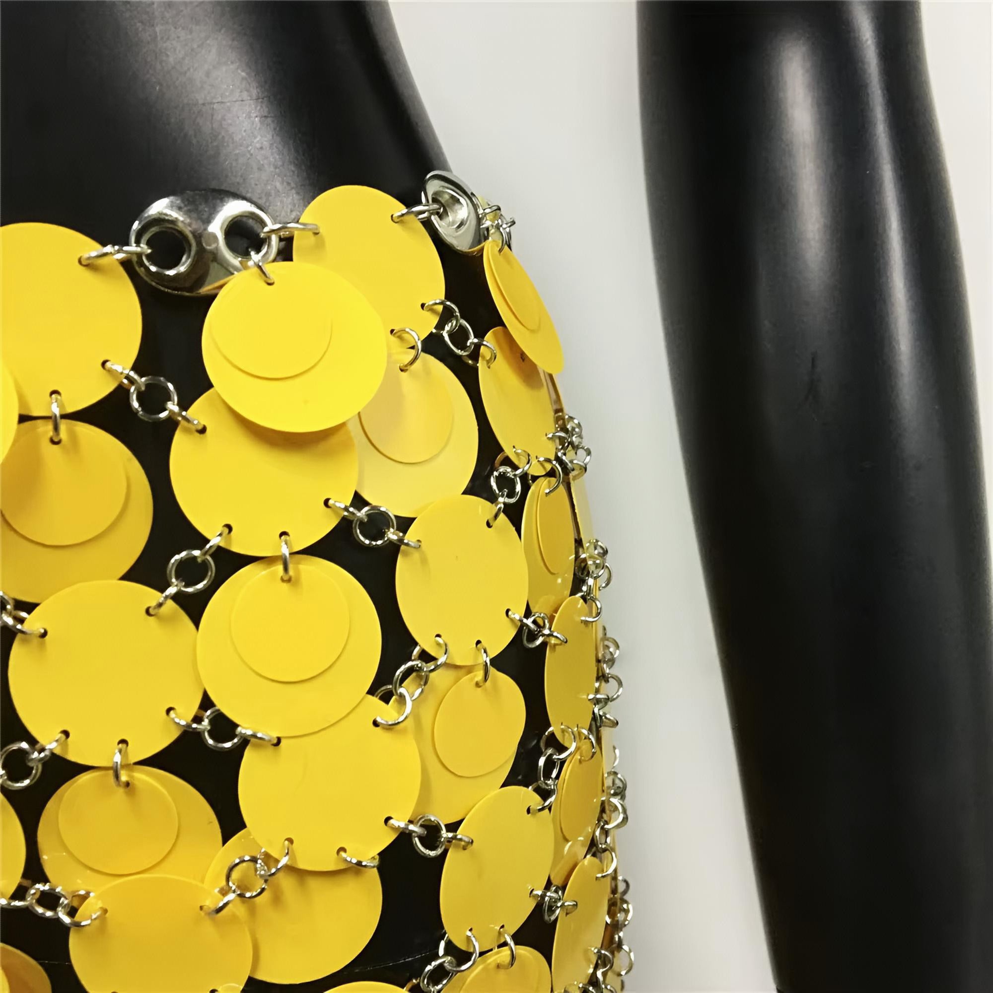 Yellow circular patterned skirt on a black mannequin against a white background