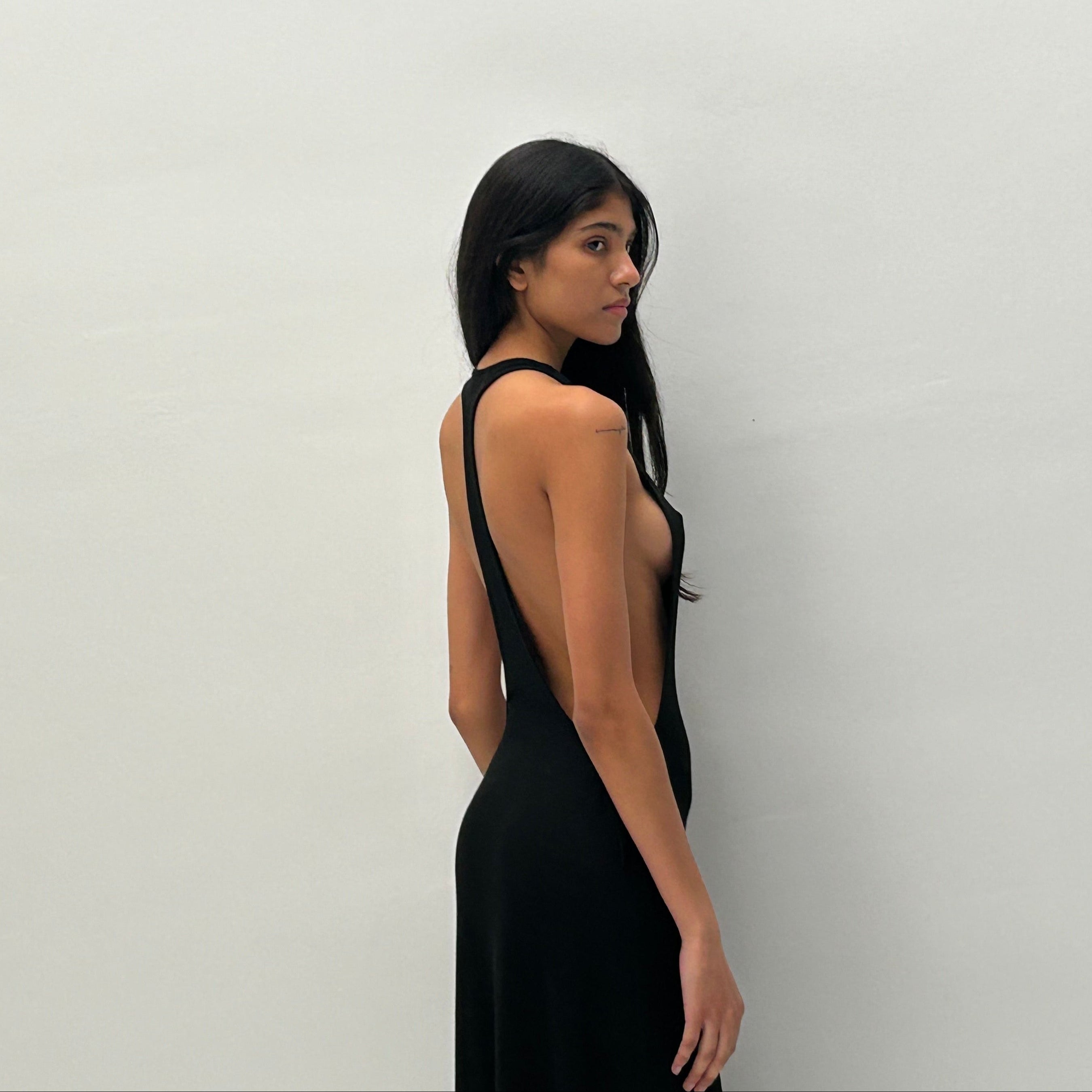 Woman wearing a black dress against a plain background