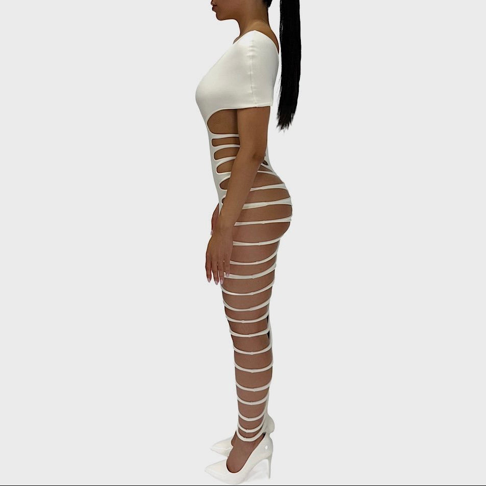 Woman wearing a white outfit with striped leggings on a plain background