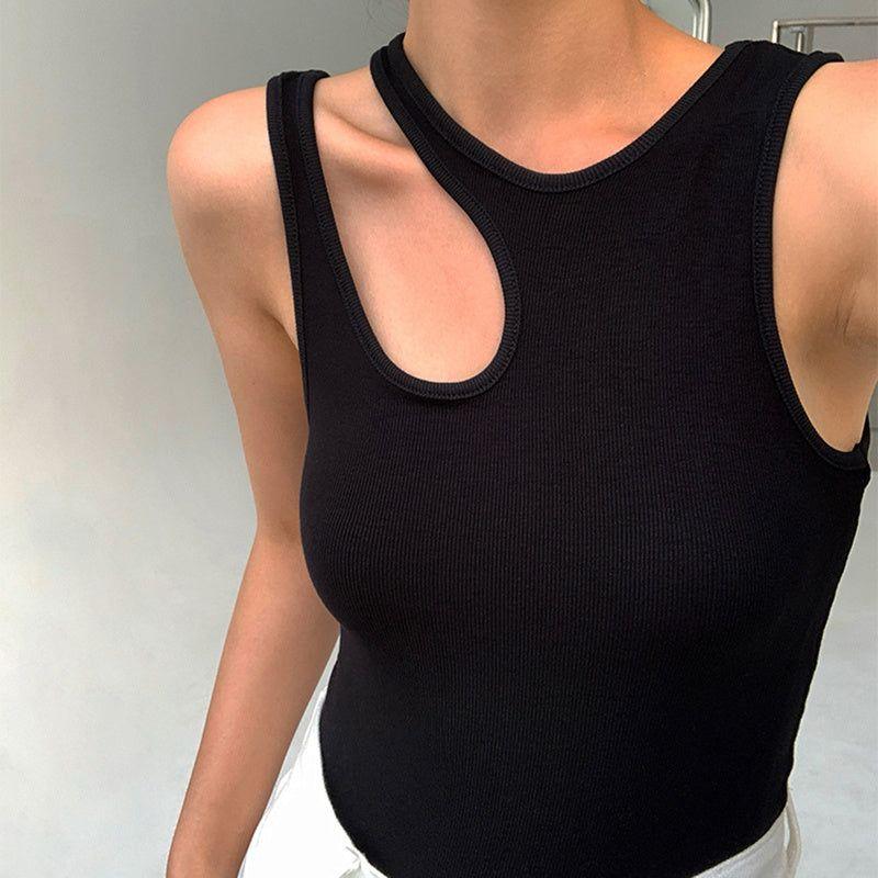 Person wearing a black tank top against a neutral background