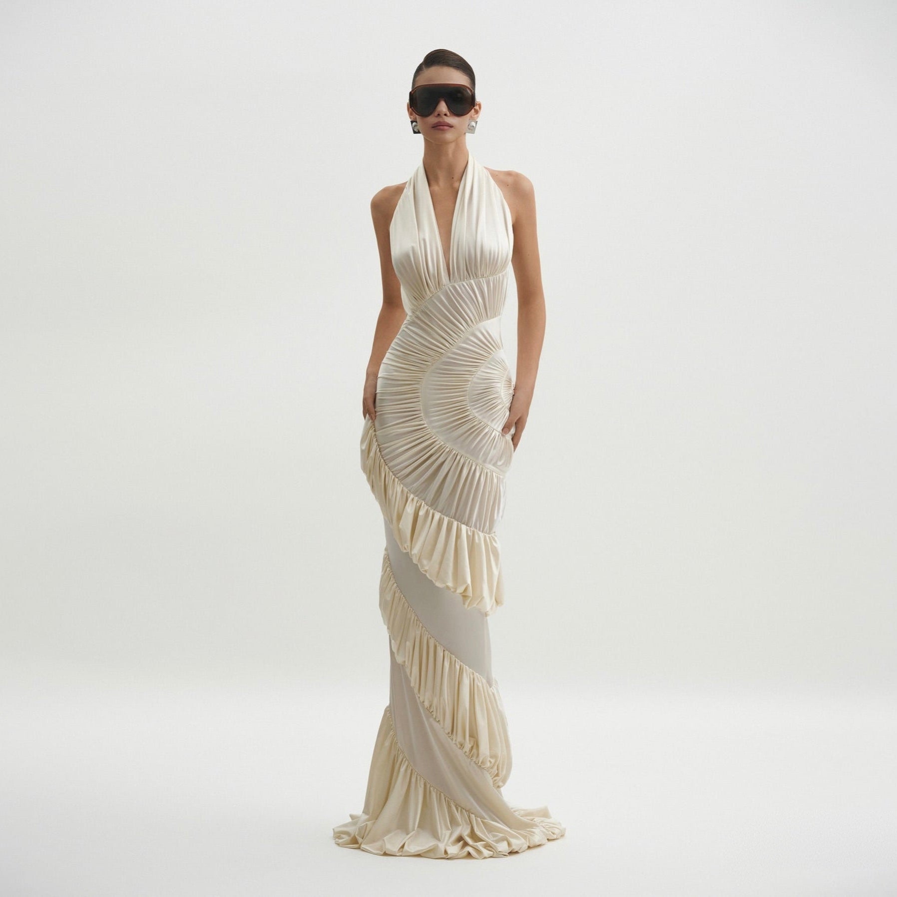 Woman wearing a white evening gown on a plain background