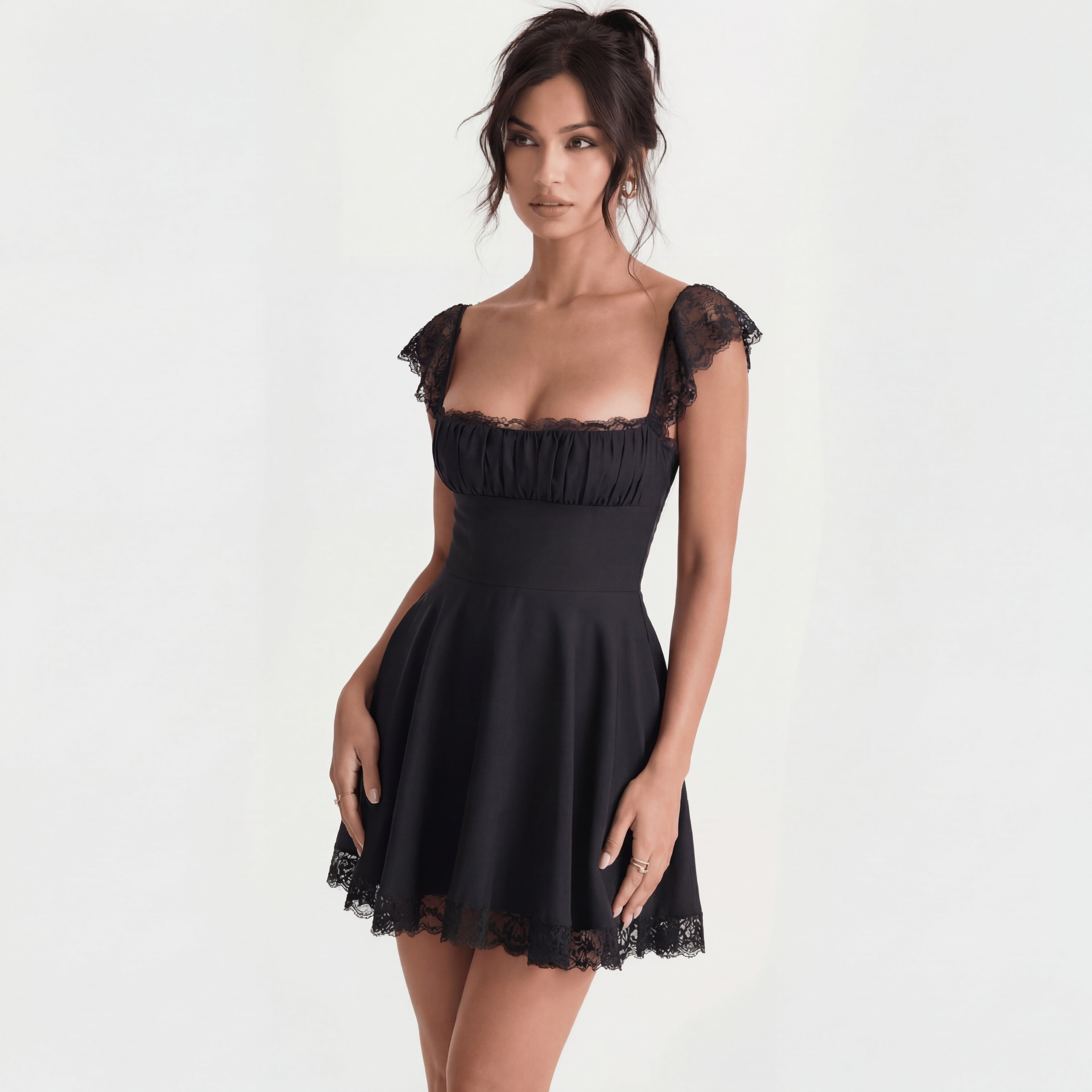 Woman wearing a black dress with lace details on a white background