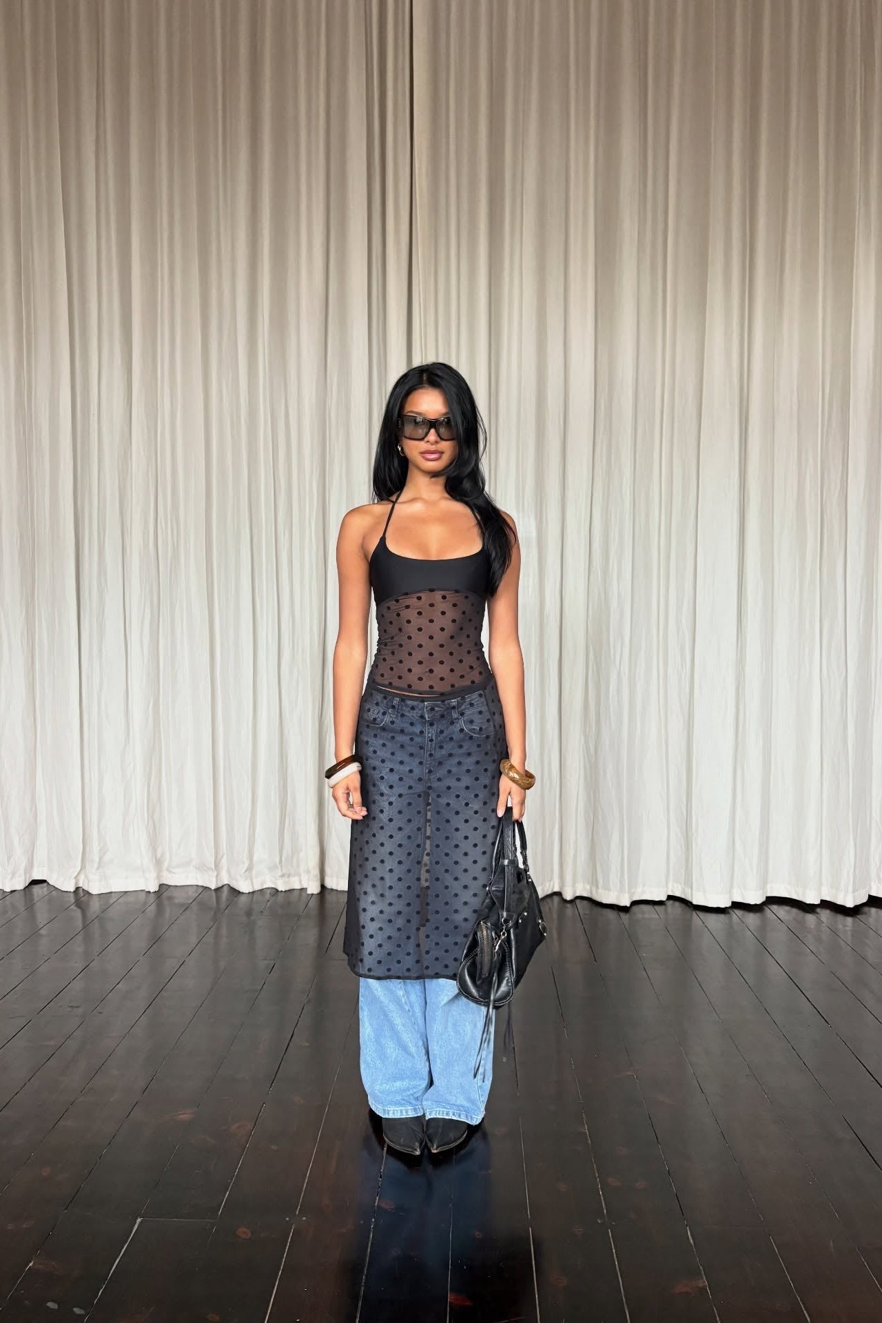 Close-up of sheer polka dot mesh fabric on black two-piece set