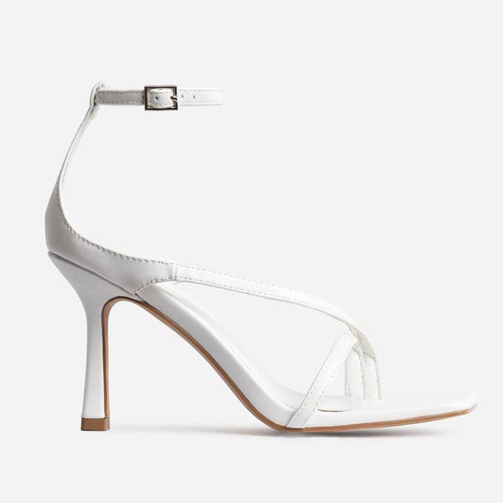 White high-heeled shoe with clear strap on a white background