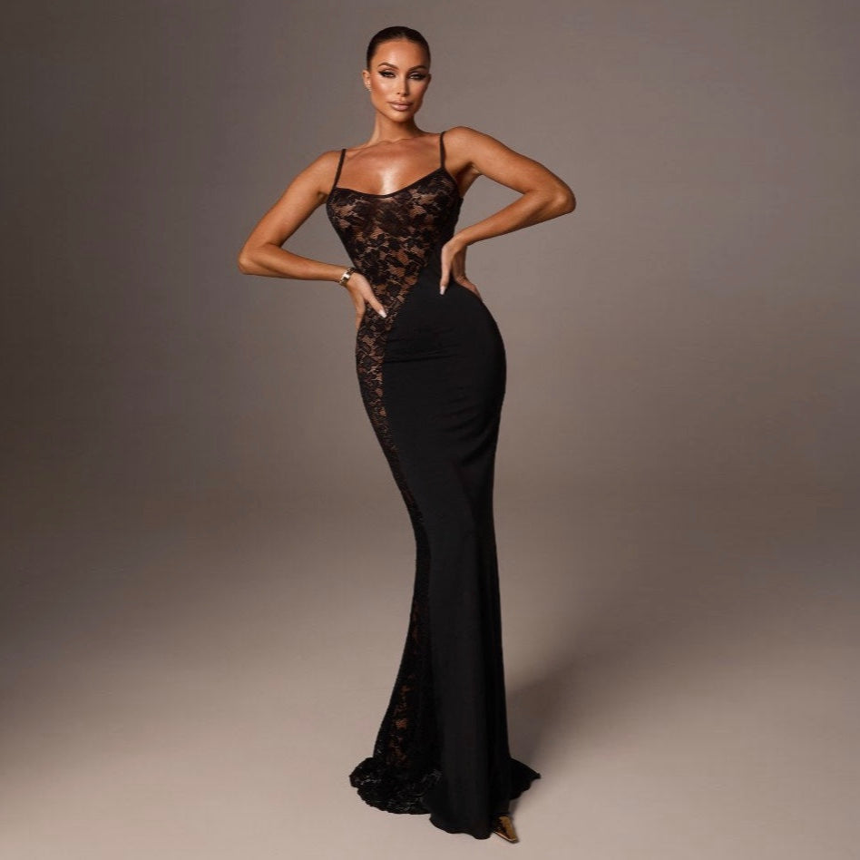 Woman wearing a black lace evening gown against a gray background