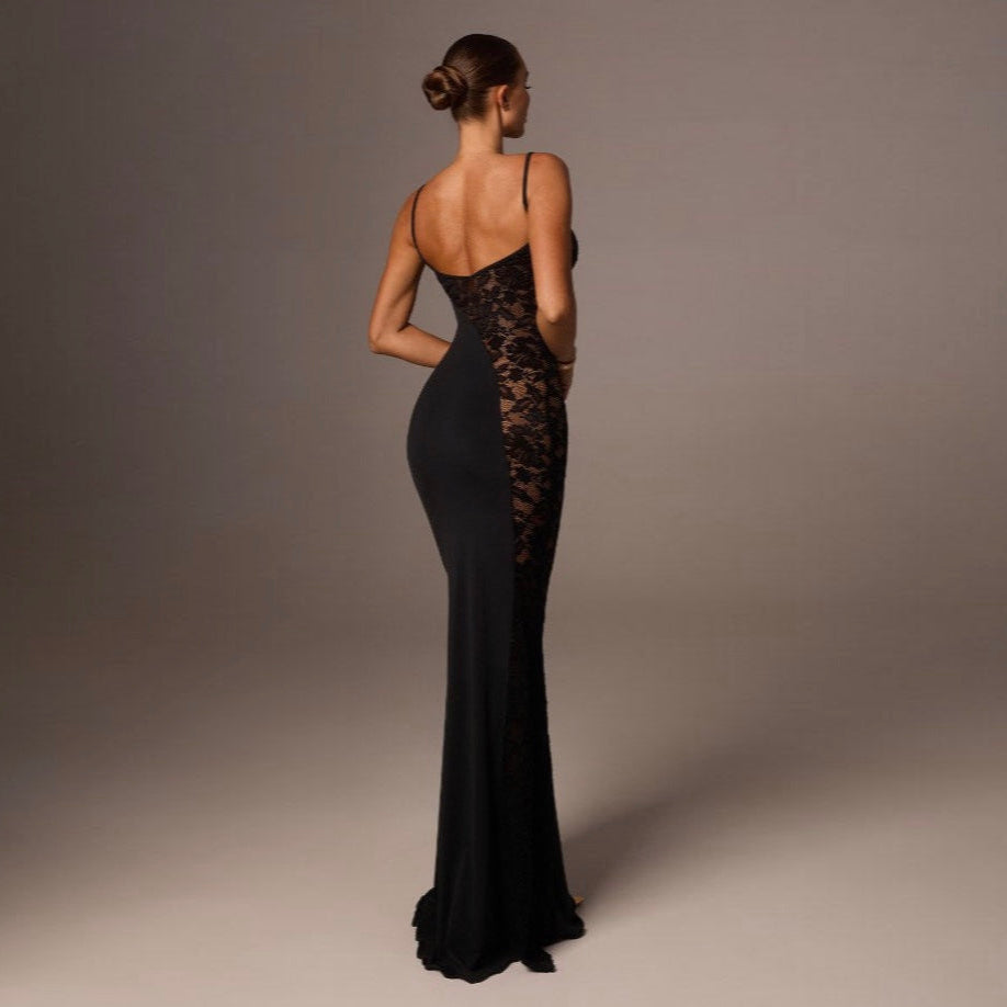 Woman wearing a black lace evening gown against a gray background
