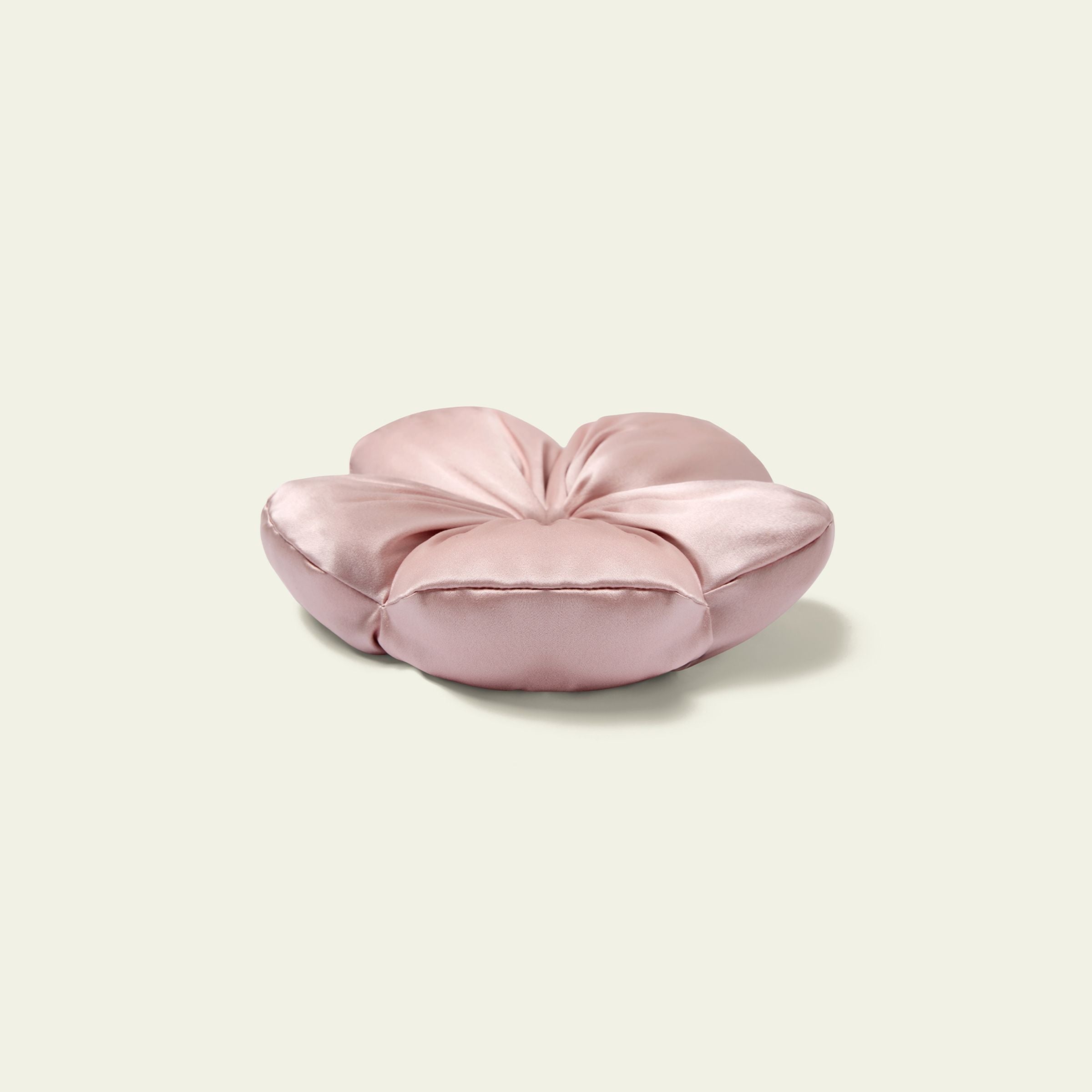 Pink heart-shaped pillow on a light beige background