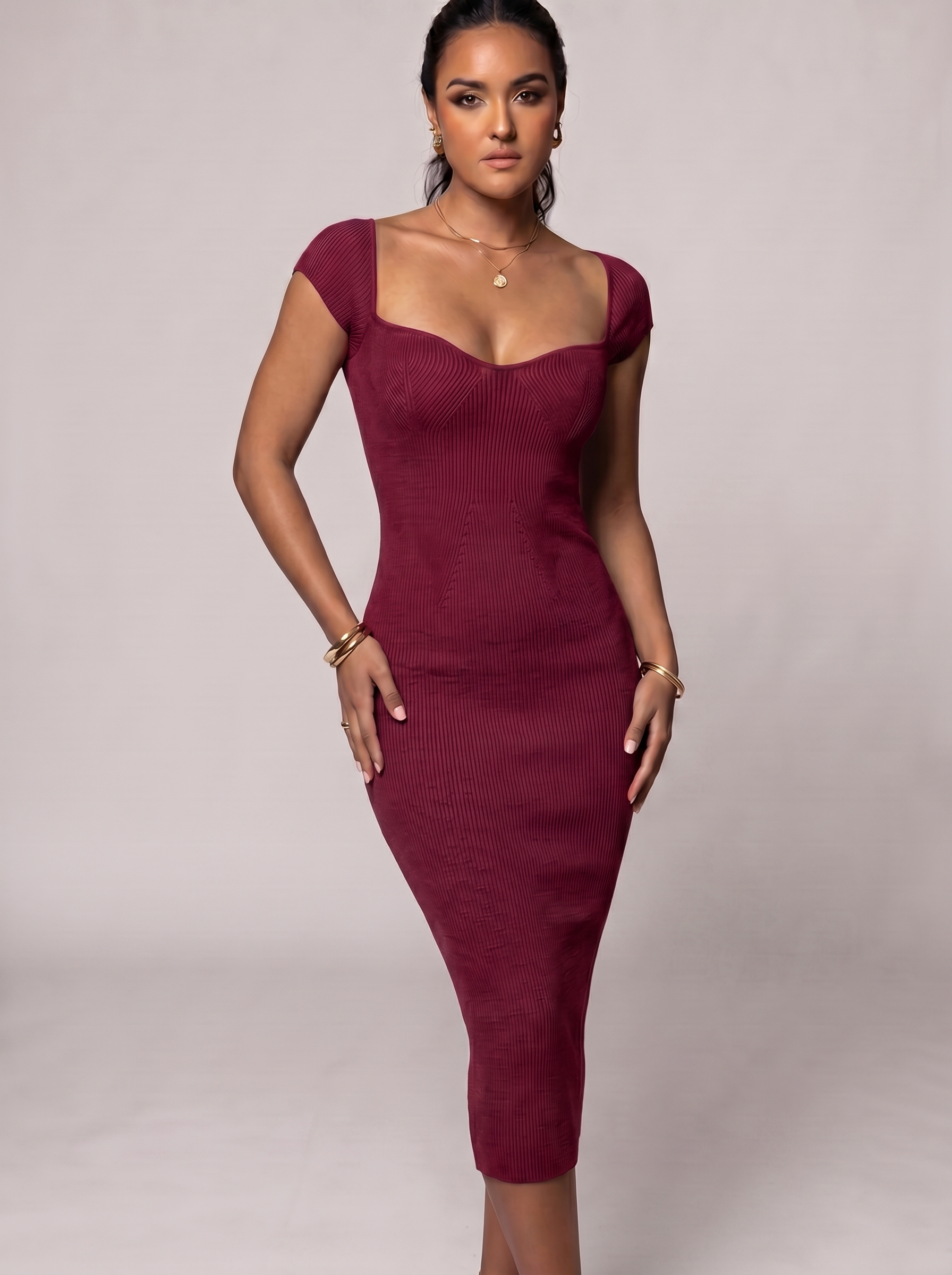 Woman wearing a burgundy dress against a plain background