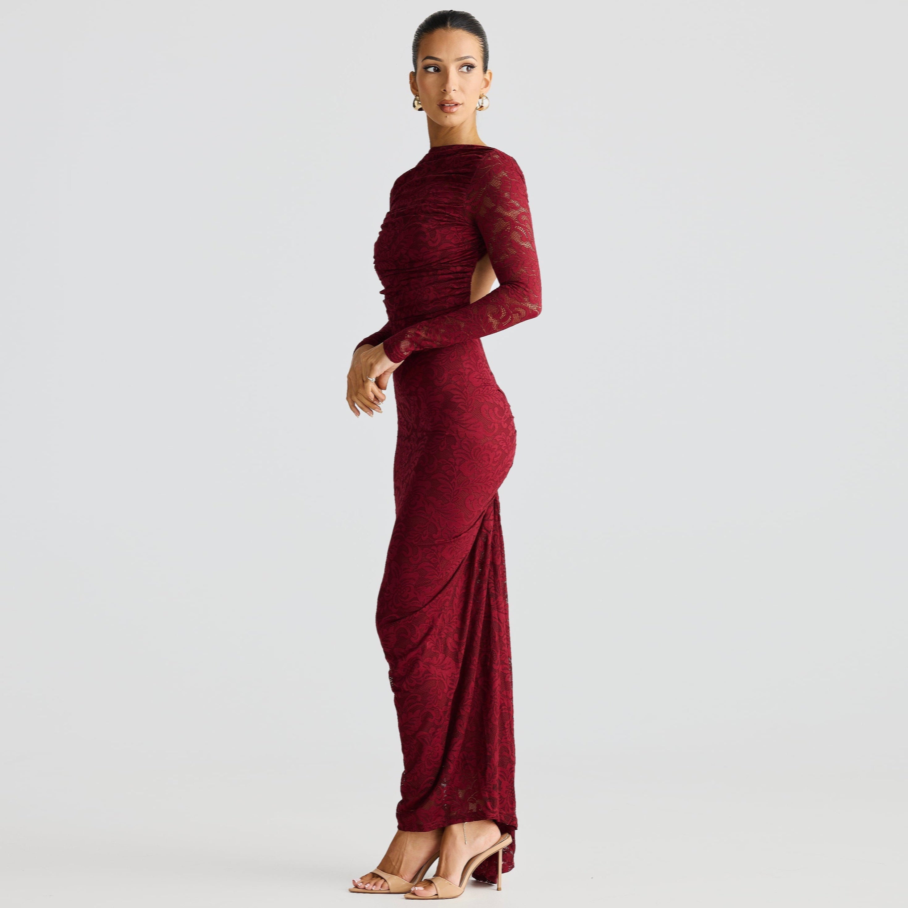 Woman wearing a burgundy evening gown on a light gray background