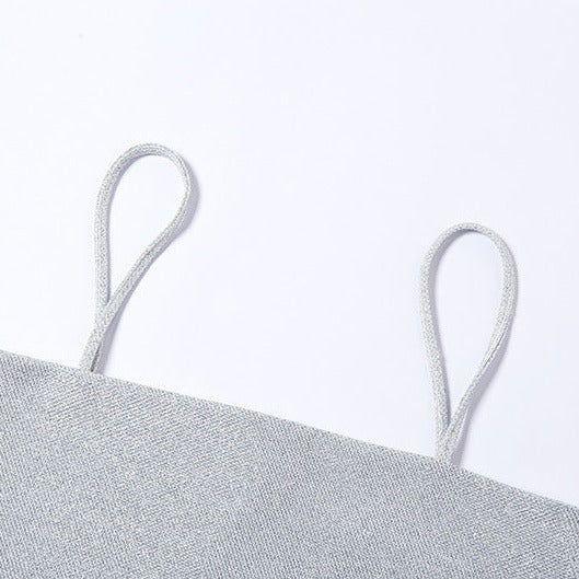 Close-up of a silver top with thin straps on a white background