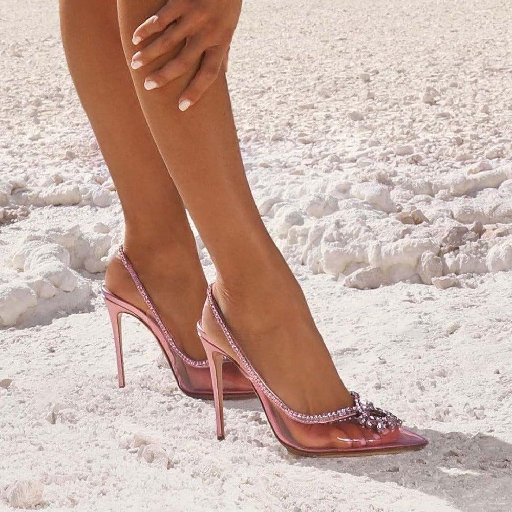Pink high-heeled shoes with clear straps on a light background