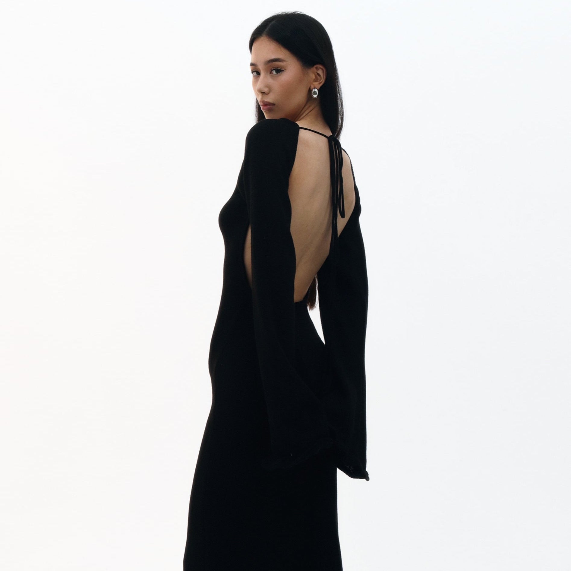 Woman wearing a black dress with cut-out design on a white background