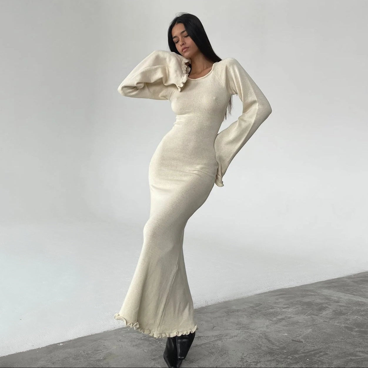 Woman wearing a white dress with puffed sleeves against a plain background