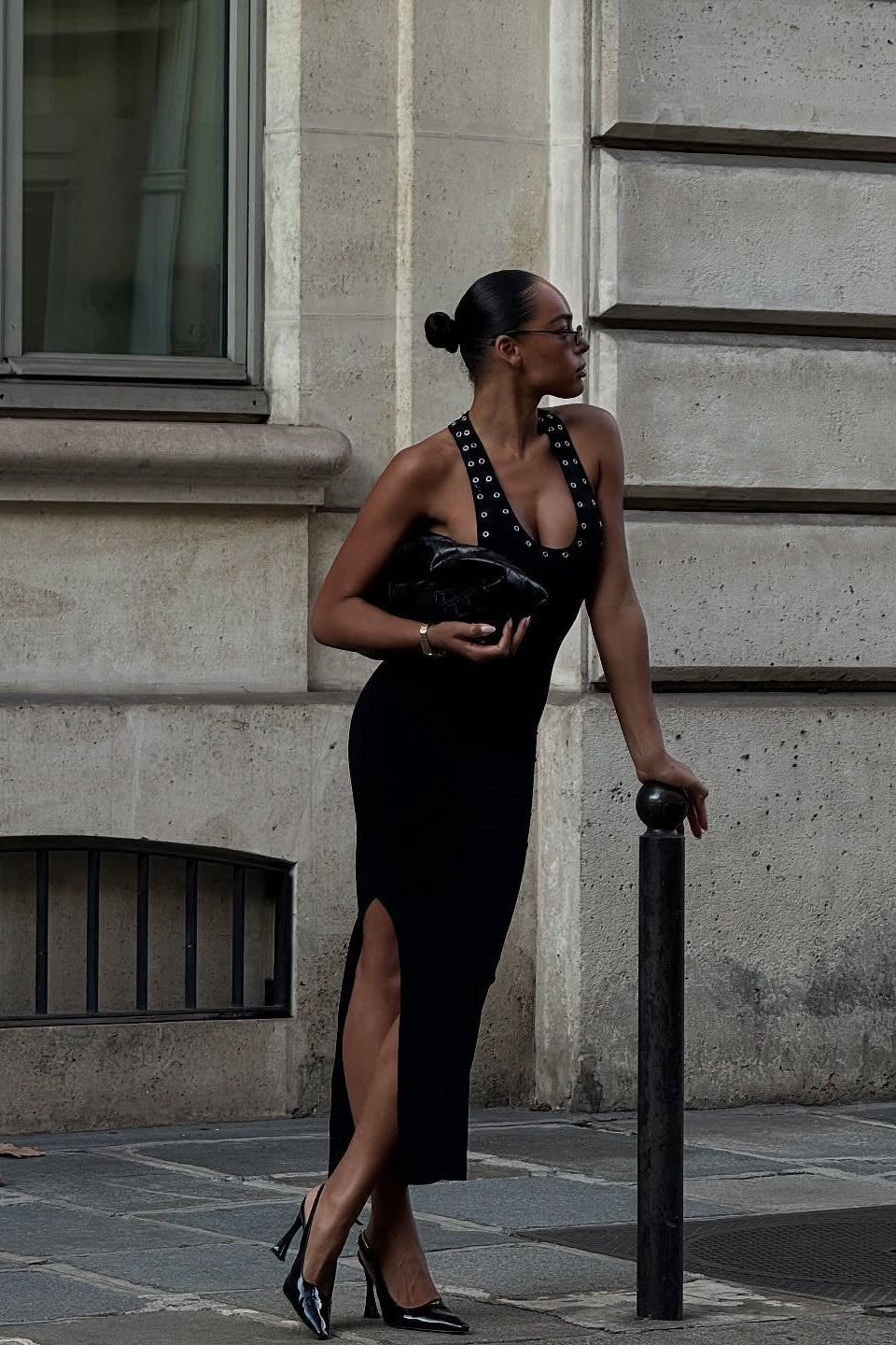 Close-up of eyelet trim and low scoop neckline on black midi dress