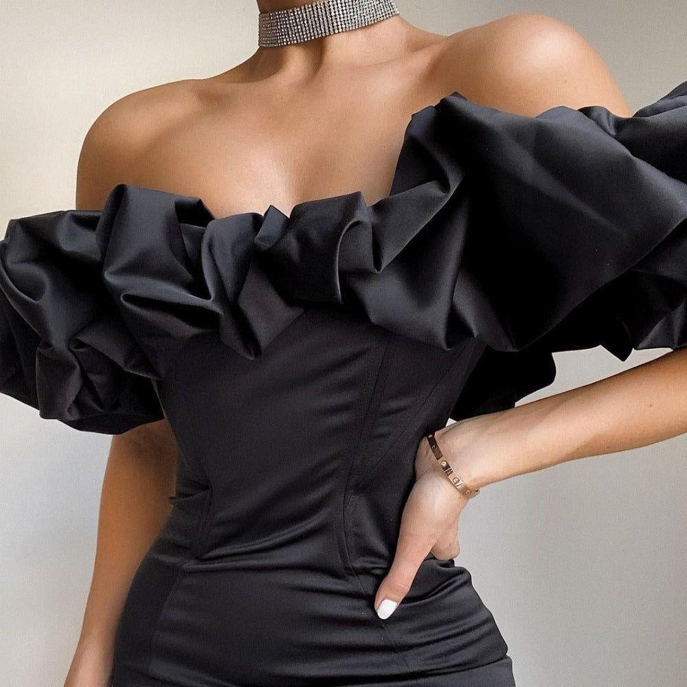 Black off-shoulder top with ruffled sleeves on a neutral background