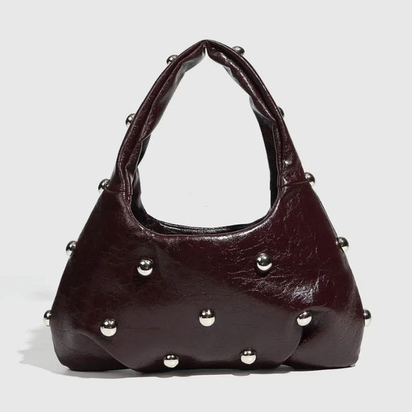 Dark faux leather handbag with metal stud embellishments, edgy accessory for party or night-out.