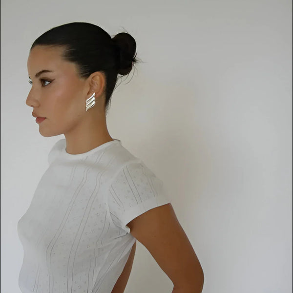 White short-sleeve top with subtle embroidered pattern, minimalist style