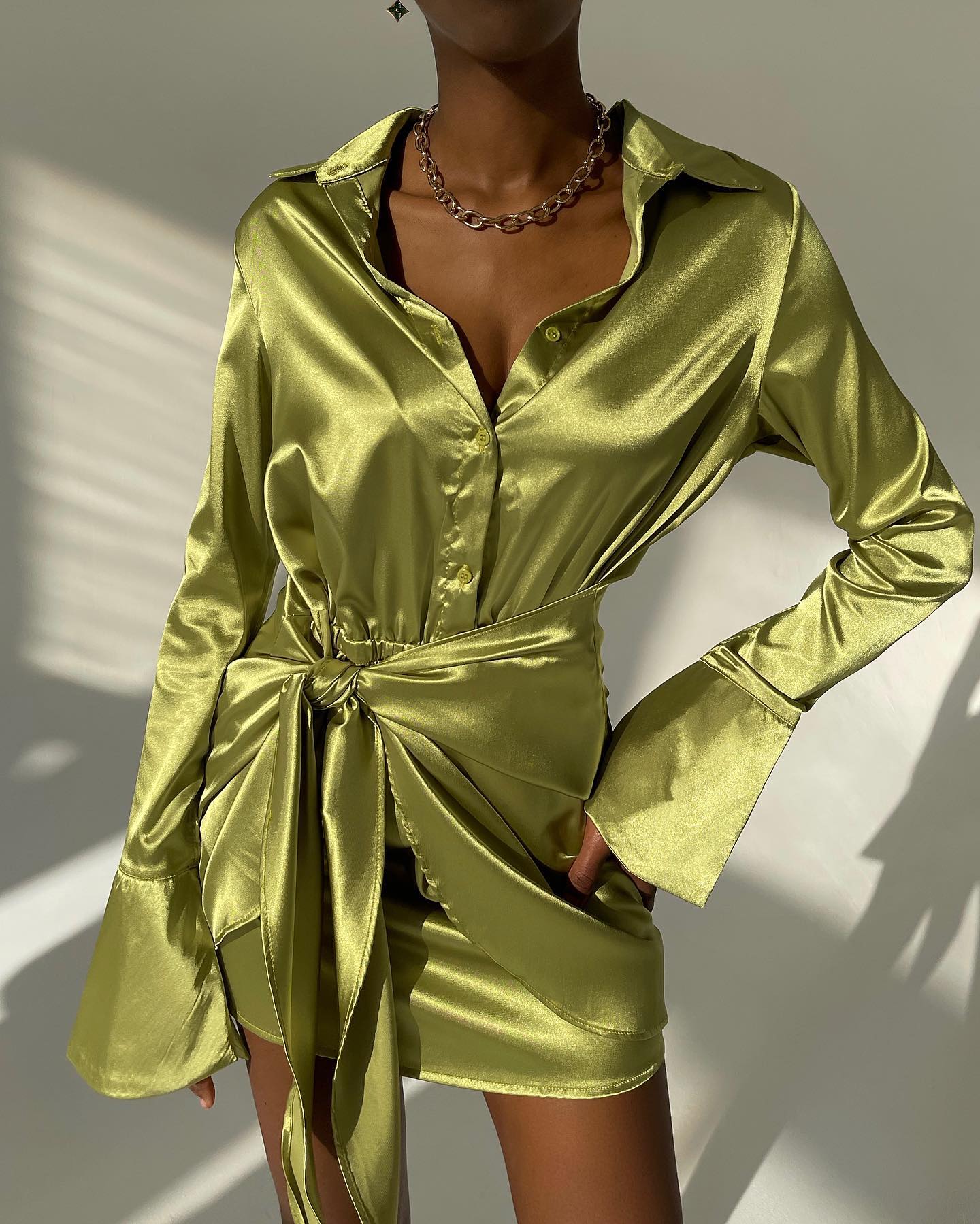 Jamaica green satin mini dress with long sleeves, button-down front, and a knotted waist tied for a chic look.