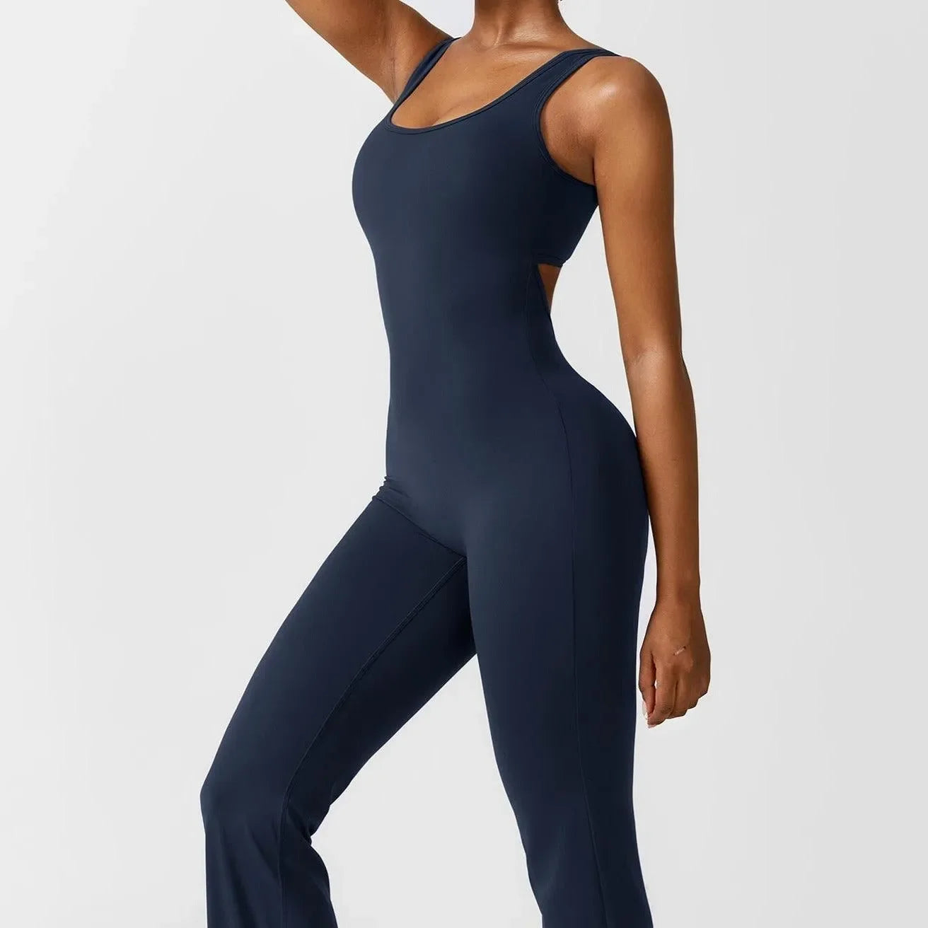 Dark blue push-up jumpsuit with a fitted silhouette and cut-out detail, styled with minimal accessories for a sleek look.