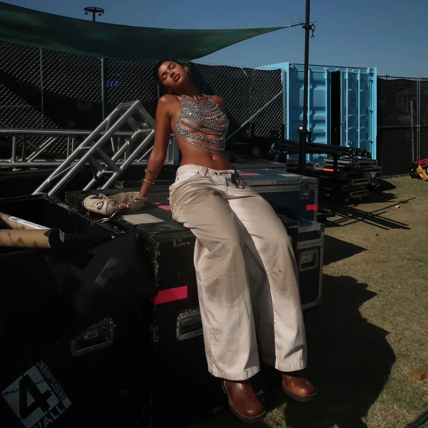 chain crop top with beige wide-leg pants and brown boots, festival style