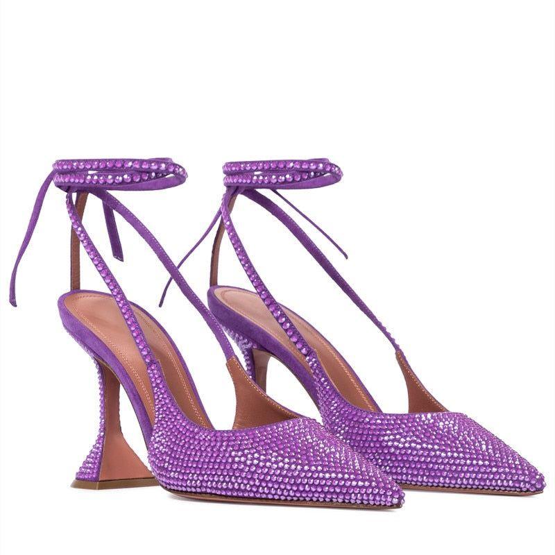 Purple high-heeled shoes with rhinestone embellishments on a white background