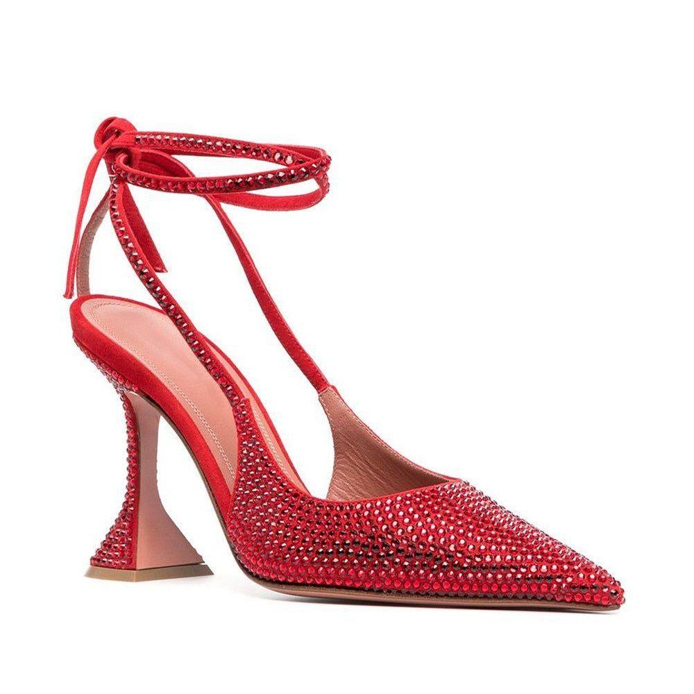 Red high-heeled shoe with embellishments on a white background