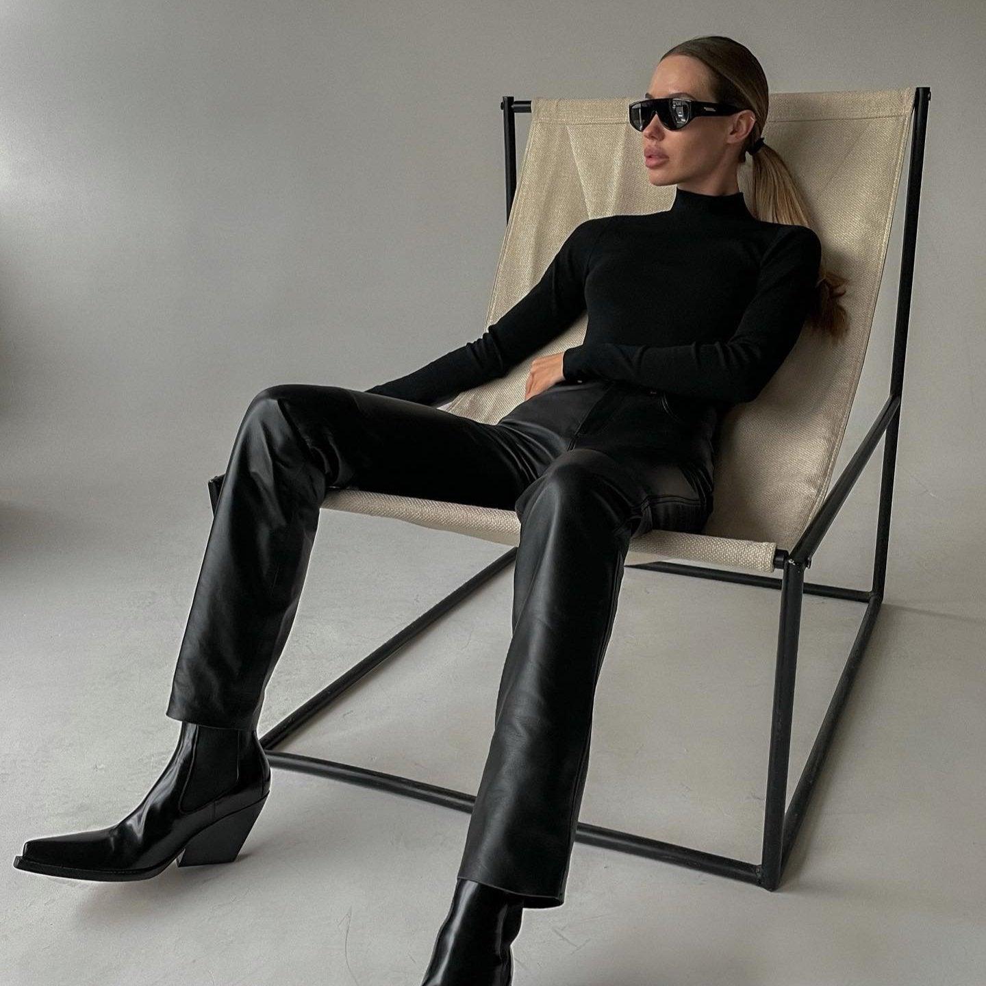 black turtleneck top with leather pants and ankle boots, sleek fashion style