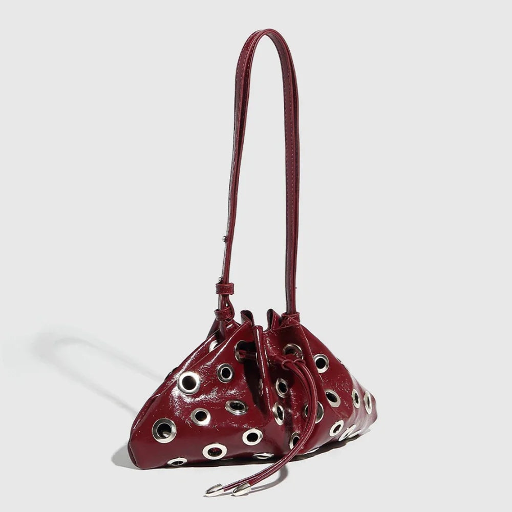burgundy patent leather handbag with grommet details