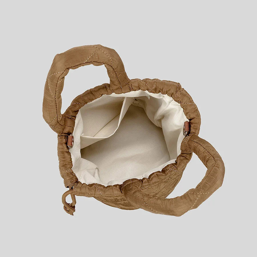 Brown ruched tote bag with cream interior lining.