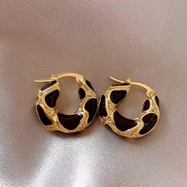 gold and black hoop earrings with abstract design