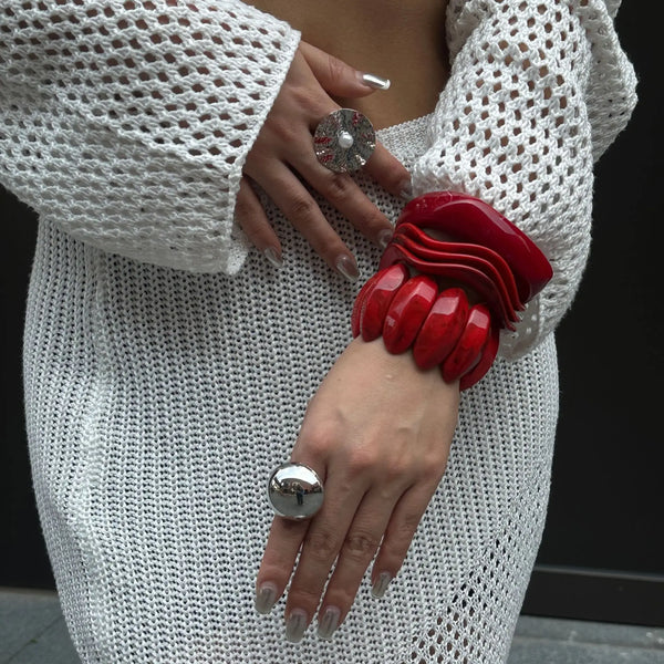 crochet mini dress with red statement bracelets and silver rings