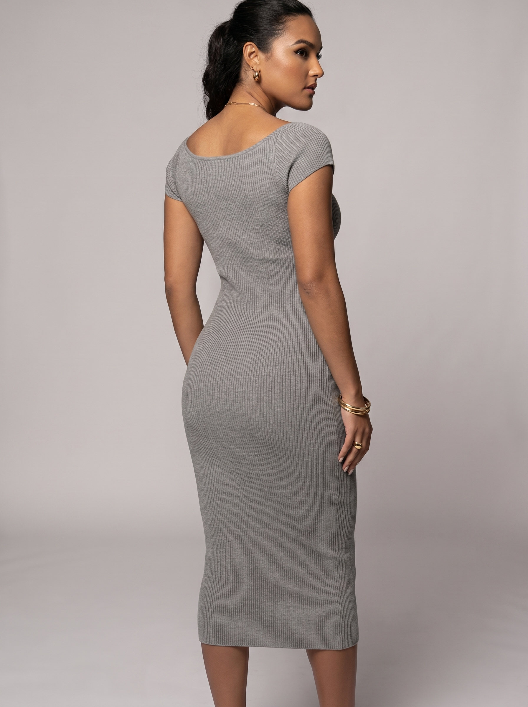 Woman wearing a gray dress against a plain background