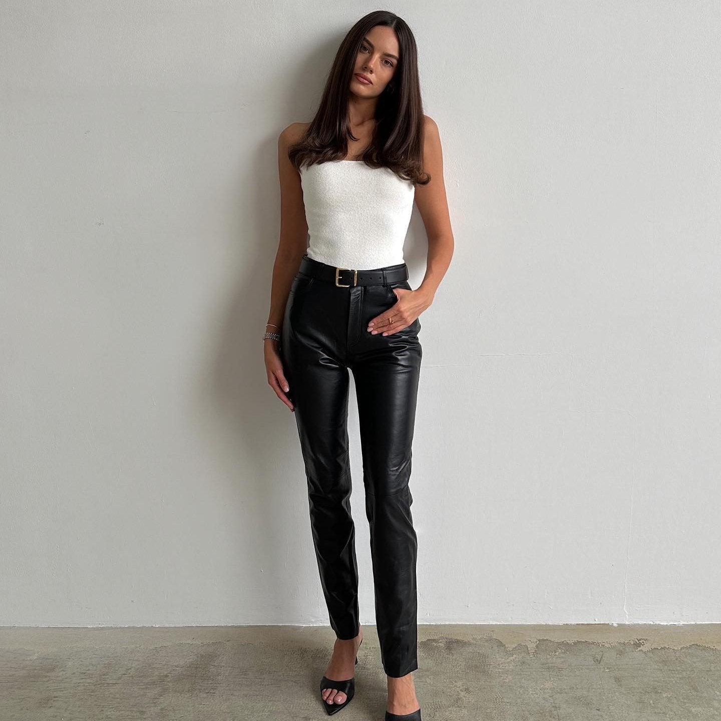 White knitted tube top paired with high-waisted black leather pants, styled for a chic summer look.