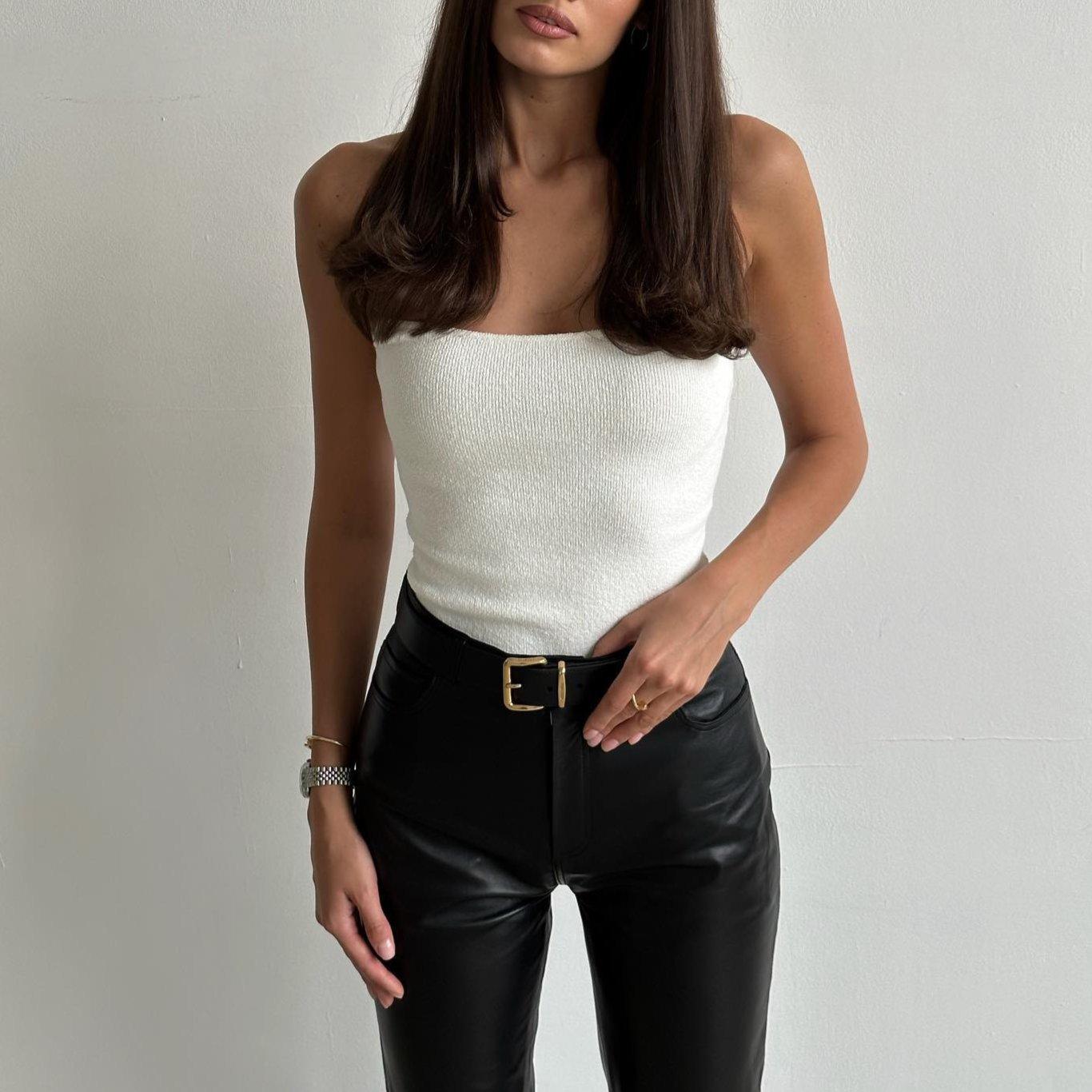 White knitted tube top with a fitted design, styled with high-waisted black leather pants for a chic summer look.