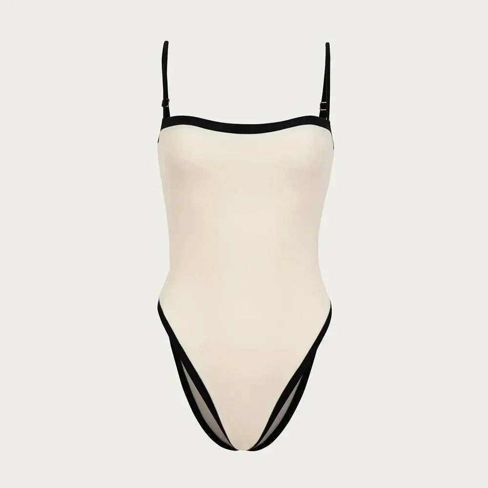 Ivory one-piece swimsuit with black trim, featuring slender straps and a high-leg cut for a flattering fit.