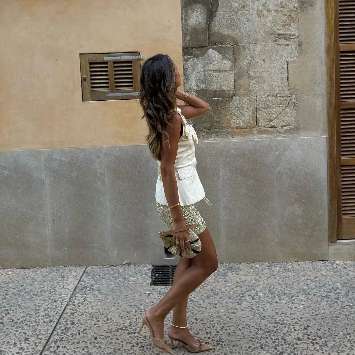Linen button-up top in soft cream, styled with a chic mini skirt and nude heels for a sophisticated look.