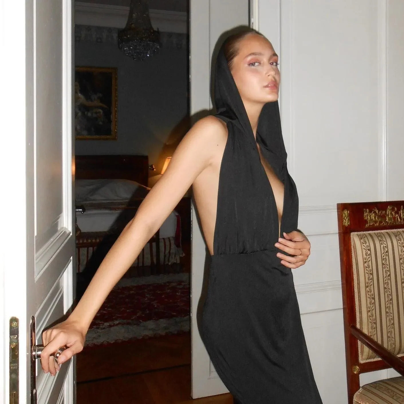 Backless black evening dress with a hood.