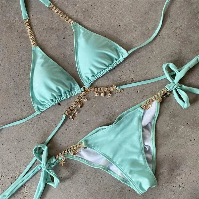 Mint bikini with gold chain details and seashell charms.