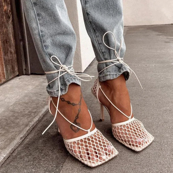 White mesh stiletto heels with lace-up detailing.