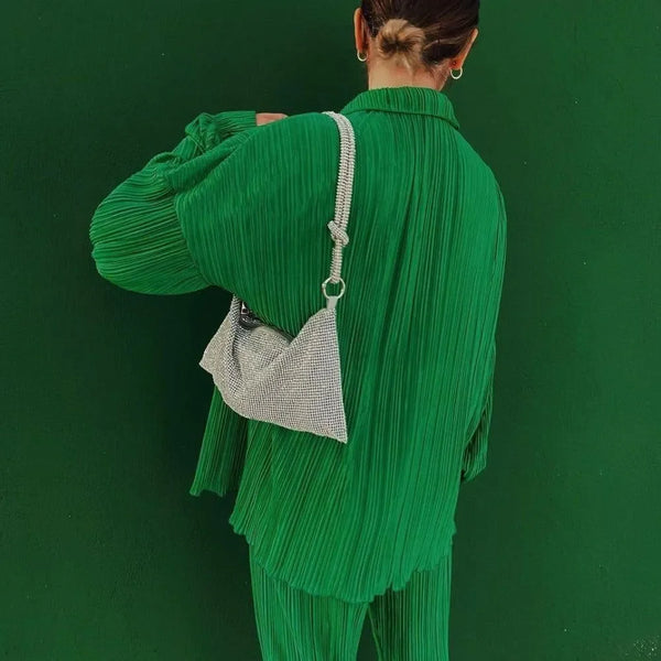 Green pleated outfit with a silver rhinestone bag.